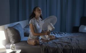 woman using fan for cooling